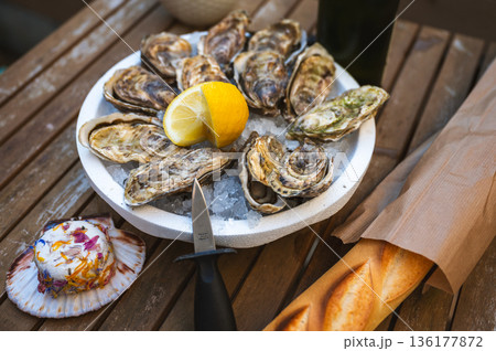 Fresh Raw Oysters with Citron, Baguette, Butter, and Cider 136177872