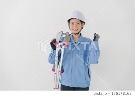 ヘルメットをかぶる作業着の女性 136178163