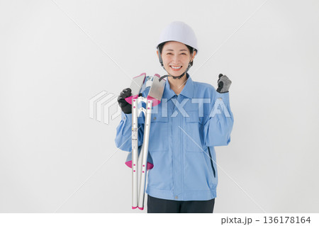 ヘルメットをかぶる作業着の女性 136178164
