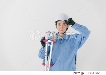 ヘルメットをかぶる作業着の女性 136178200