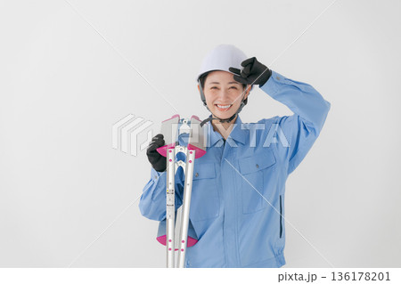 ヘルメットをかぶる作業着の女性 136178201