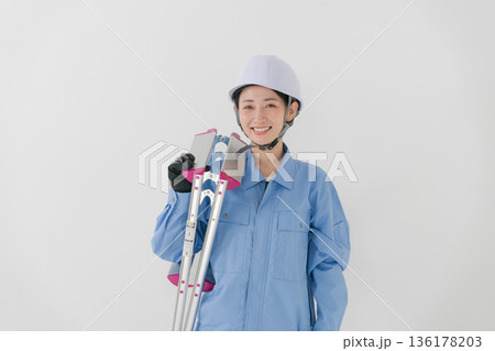 ヘルメットをかぶる作業着の女性 136178203