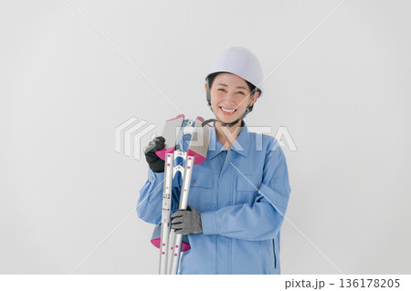 ヘルメットをかぶる作業着の女性 136178205
