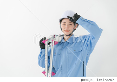 ヘルメットをかぶる作業着の女性 136178207