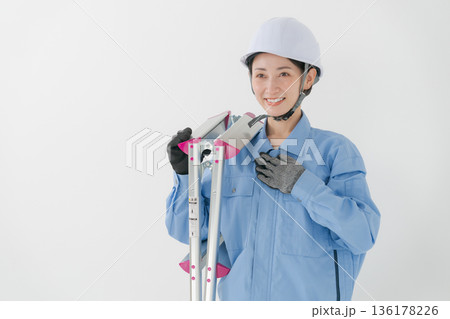 ヘルメットをかぶる作業着の女性 ヘルメットをかぶる作業着の女性 136178226