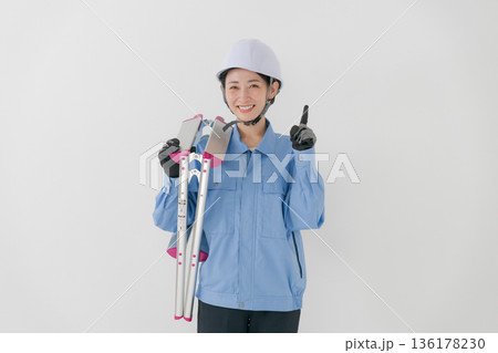 ヘルメットをかぶる作業着の女性 ヘルメットをかぶる作業着の女性 136178230