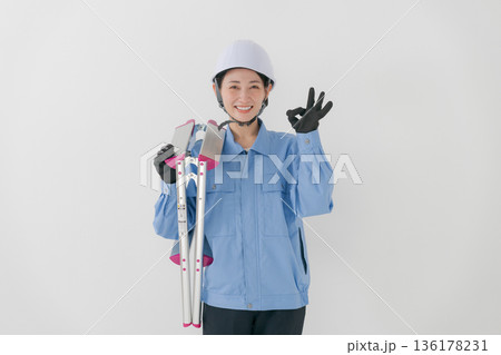 ヘルメットをかぶる作業着の女性 ヘルメットをかぶる作業着の女性 136178231