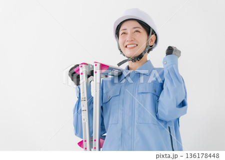 ヘルメットをかぶる作業着の女性 136178448