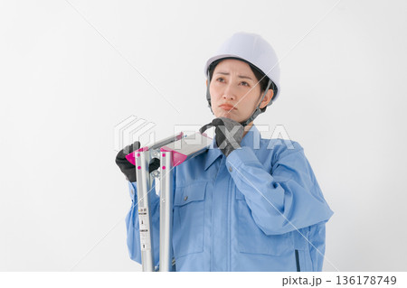 ヘルメットをかぶる作業着の女性 136178749