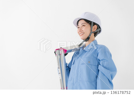 ヘルメットをかぶる作業着の女性 136178752