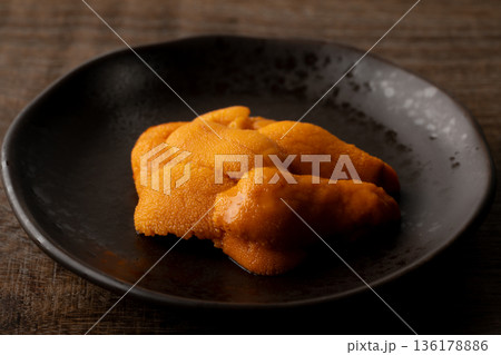 お皿に載せた生のエゾバフンウニのクローズアップ 136178886