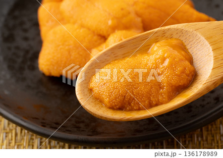 スプーンに載せた生のエゾバフンウニのクローズアップ 136178989