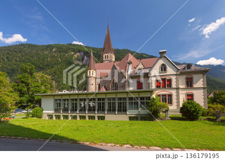 Historic church in Interlaken with green lawn and alpine backdrop 136179195