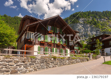 Traditional Swiss chalet with green shutters in alpine village Traditional Swiss chalet with green shutters in alpine village 136179197