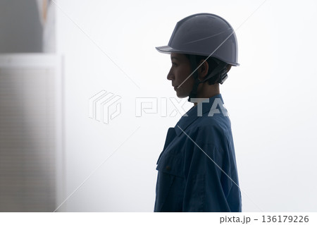 ヘルメットをかぶる作業着の女性 ヘルメットをかぶる作業着の女性 136179226