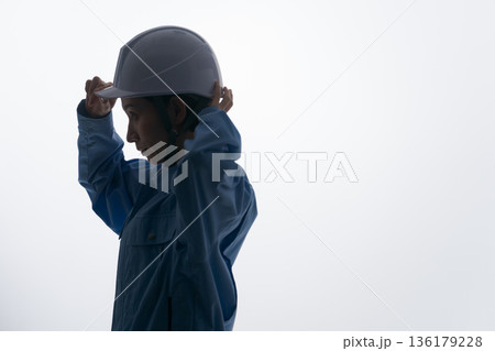 ヘルメットをかぶる作業着の女性 136179228