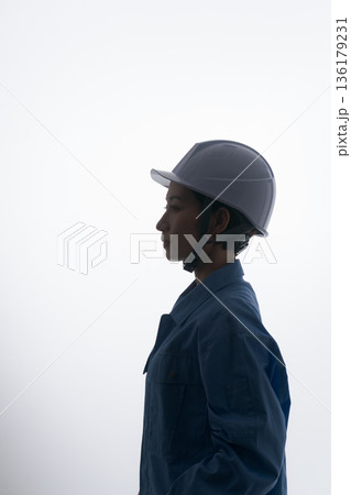 ヘルメットをかぶる作業着の女性 136179231