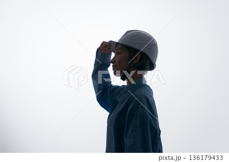 ヘルメットをかぶる作業着の女性 ヘルメットをかぶる作業着の女性 136179433