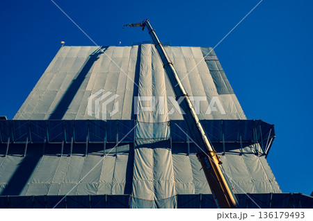 建設中のビルのクレーンと青い空　b-3 暖色寒色強調 136179493