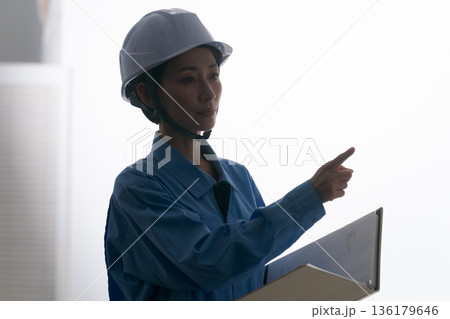 ヘルメットをかぶる作業着の女性 ヘルメットをかぶる作業着の女性 136179646