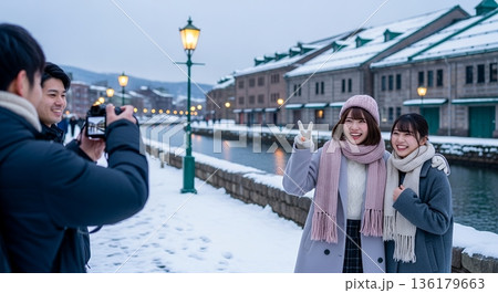 観光地で男性に写真を撮ってもらっている2人の女性 136179663