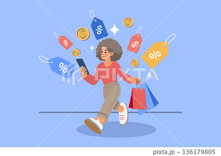 A happy woman walking while holding shopping bags and using a smartphone. Illustration featuring floating discount price tags and gold coins on a blue background, representing online shopping, sales A happy woman walking while holding shopping bags and using a smartphone. Illustration featuring floating discount price tags and gold coins on a blue background, representing online shopping, sales 136179805