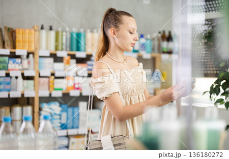 Girl in summer clothes buys paracetamol medicine at pharmacy Girl in summer clothes buys paracetamol medicine at pharmacy 136180272