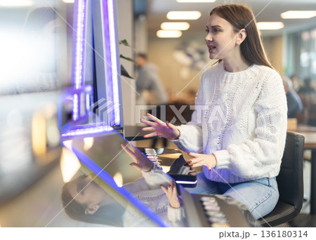 Girl is playing slot machines in casino Girl is playing slot machines in casino 136180314