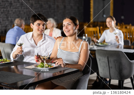 Cheerful young couple spending time together in restaurant Cheerful young couple spending time together in restaurant 136180424