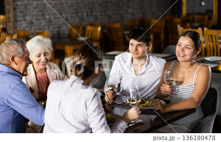 Young couple spending time with aged friends in restaurant 136180478