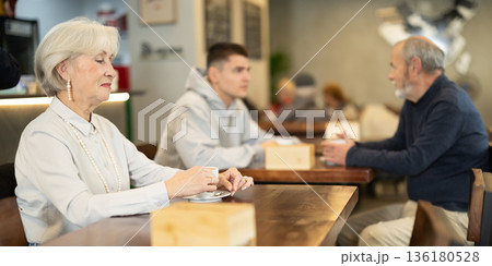 Eldery woman drinks coffee in cafe 136180528