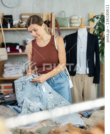 Adult woman choosing jeans in clothing store Adult woman choosing jeans in clothing store 136180611