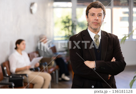 Adult man in business suit posing in office 136181128