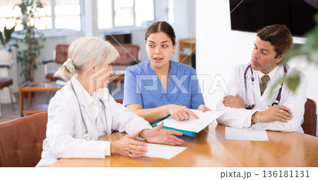 Young female doctor conducting medical council with experienced colleagues Young female doctor conducting medical council with experienced colleagues 136181131