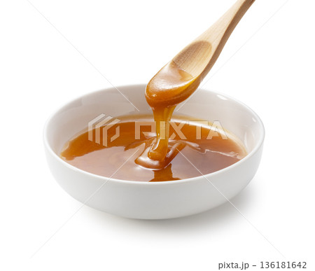 白い器のマヌカハニーと木のスプーン 滴る蜂蜜 白背景 切り抜き素材 136181642