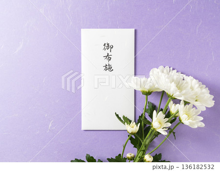 紫色の和紙を背景にした「御布施」の封筒と白い菊の花(仏事・葬儀イメージ) 紫色の和紙を背景にした「御布施」の封筒と白い菊の花(仏事・葬儀イメージ) 136182532