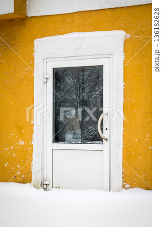 Snow Covered Basement Door On Yellow Residential Building Wall Snow Covered Basement Door On Yellow Residential Building Wall 136182628