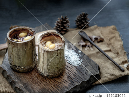 Sticky Rice Cooked with Coconut milk (Khao lam) or Glutinous rice roasted in bamboo joints on wooden, Thai dessert concept. 136183033