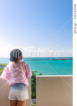 沖縄の海を眺める女性の後ろ姿　リゾートで過ごす穏やかな時間 136183544