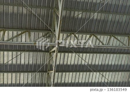 Under Large Steel Roof Structure, A grand photo of under large steel structure, massive beams and trusses towering in light on concrete floor, for modern architecture or engineering documentary. 136183549