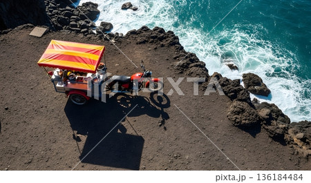 Aerial View Of Red Motorcycle Sidecar On Rocky Coastline With Turquoise Water 136184484