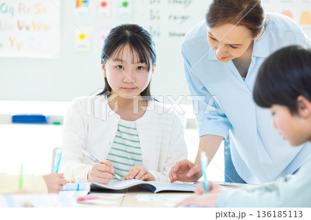 教育　英会話教室でレッスンを受ける子供とネイティブ講師 136185113