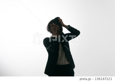 頭をぐしゃぐしゃにするスーツの女性 頭をぐしゃぐしゃにするスーツの女性 136187221