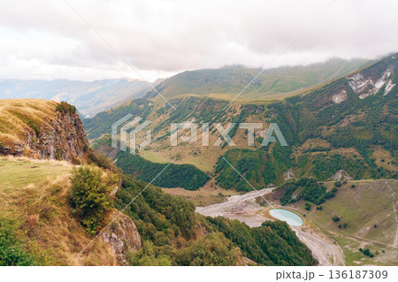 Exploring a vast landscape with hills, valleys, and a water body in the distance 136187309