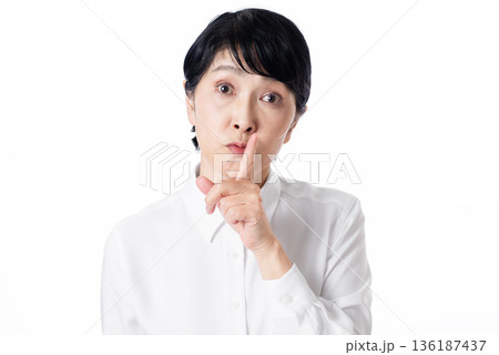 人差し指を立てて静かにするようジェスチャーするシニア女性 人差し指を立てて静かにするようジェスチャーするシニア女性 136187437