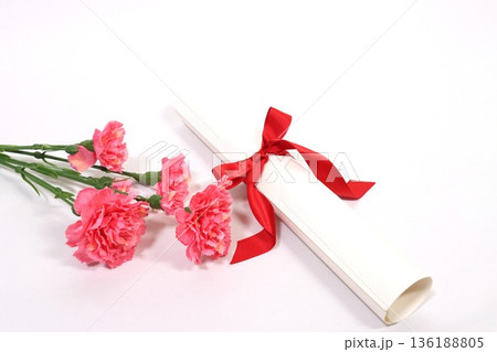 ピンクのカーネーションと赤いリボンが結ばれた卒業証書 136188805