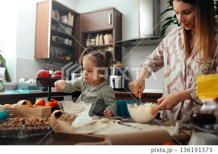 Baking fun in the kitchen with a child preparing food and enjoying time together while mixing ingredients and having a good time 136191373