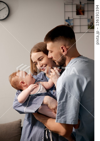 Loving family moment with parents cherishing their baby in a cozy home setting, showcasing joy and connection, family bonding concept 136191394