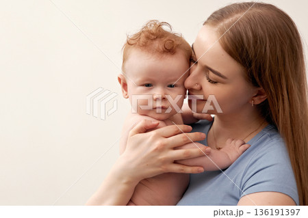Cherished moments between mother and baby showcasing love, tenderness, and connection in a serene indoor setting, emphasizing the bond of family and nurturing care concept 136191397