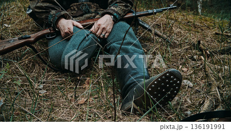 German soldier sitting in forest showcasing hobnailed jackboots and rifle German soldier sitting in forest showcasing hobnailed jackboots and rifle 136191991